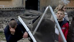 Moradora de Kiev busca abrigo com seus filhos durante ataque de mísseis russos.; Reprodução: Reuters