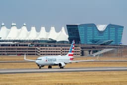 Avião da American Airlines estacionado no Aeroporto Internacional de Denver, foco em energia sustentável. Reprodução: Gizmodo