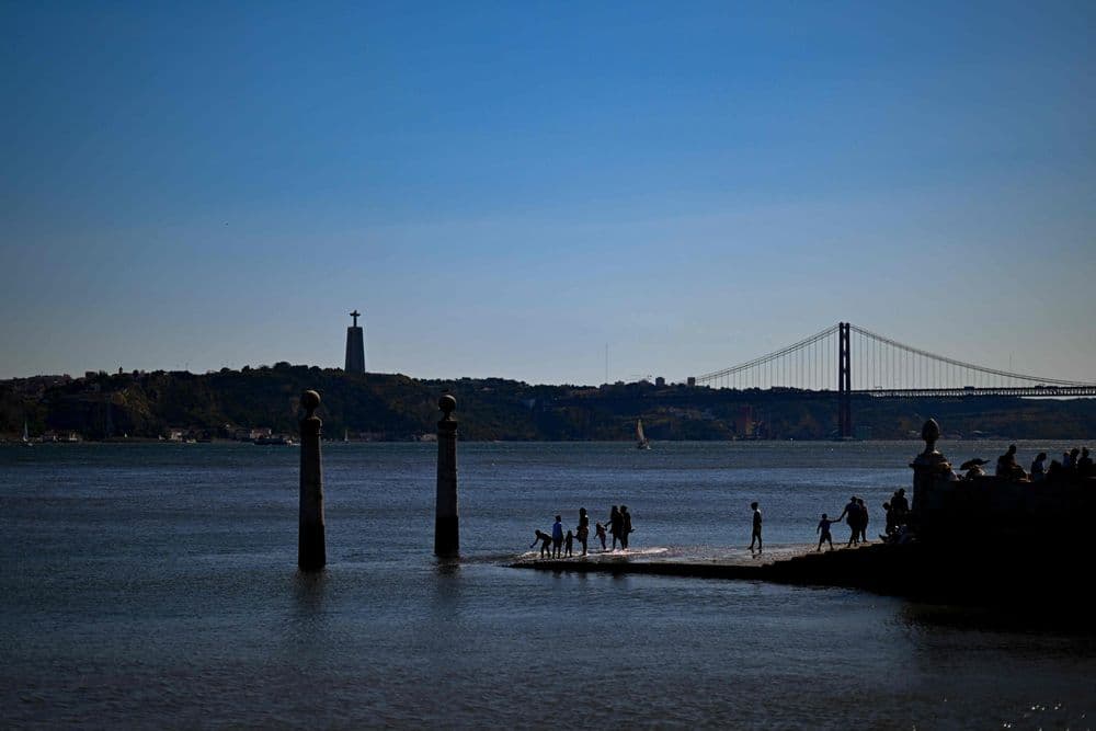 Pessoas aproveitam dia ensolarado à beira do rio em Lisboa, em meio a alerta de calor. Reprodução: Globo