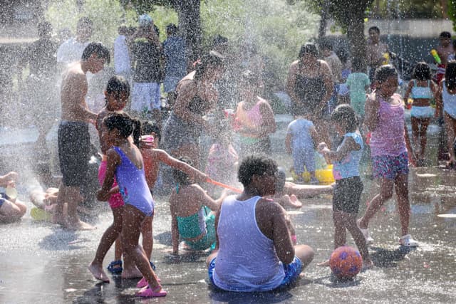 Pessoas se refrescam em fonte na área de recreação de Madrid durante onda de calor. Reprodução: Globo.