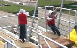 Menino quase perde o equilíbrio ao filmar carros da NASCAR devido à forte rajada de vento.; Legenda da imagem. Reprodução: iG Esportes
