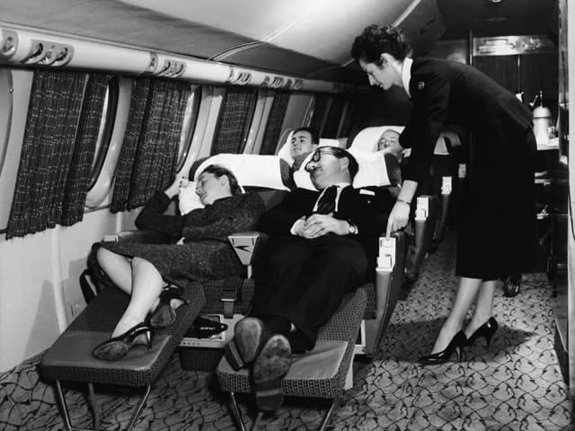 Passageiros desfrutam de conforto na primeira classe de um avião dos anos 1950. Legenda da imagem. Reprodução: Business Insider
