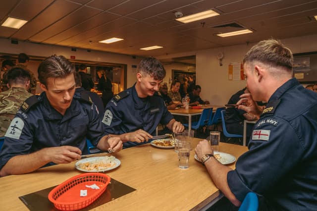 Marinheiros da Royal Navy almoçam no refeitório júnior a bordo do HMS Prince of Wales. Legenda da imagem. Reprodução: Retorno do item 11