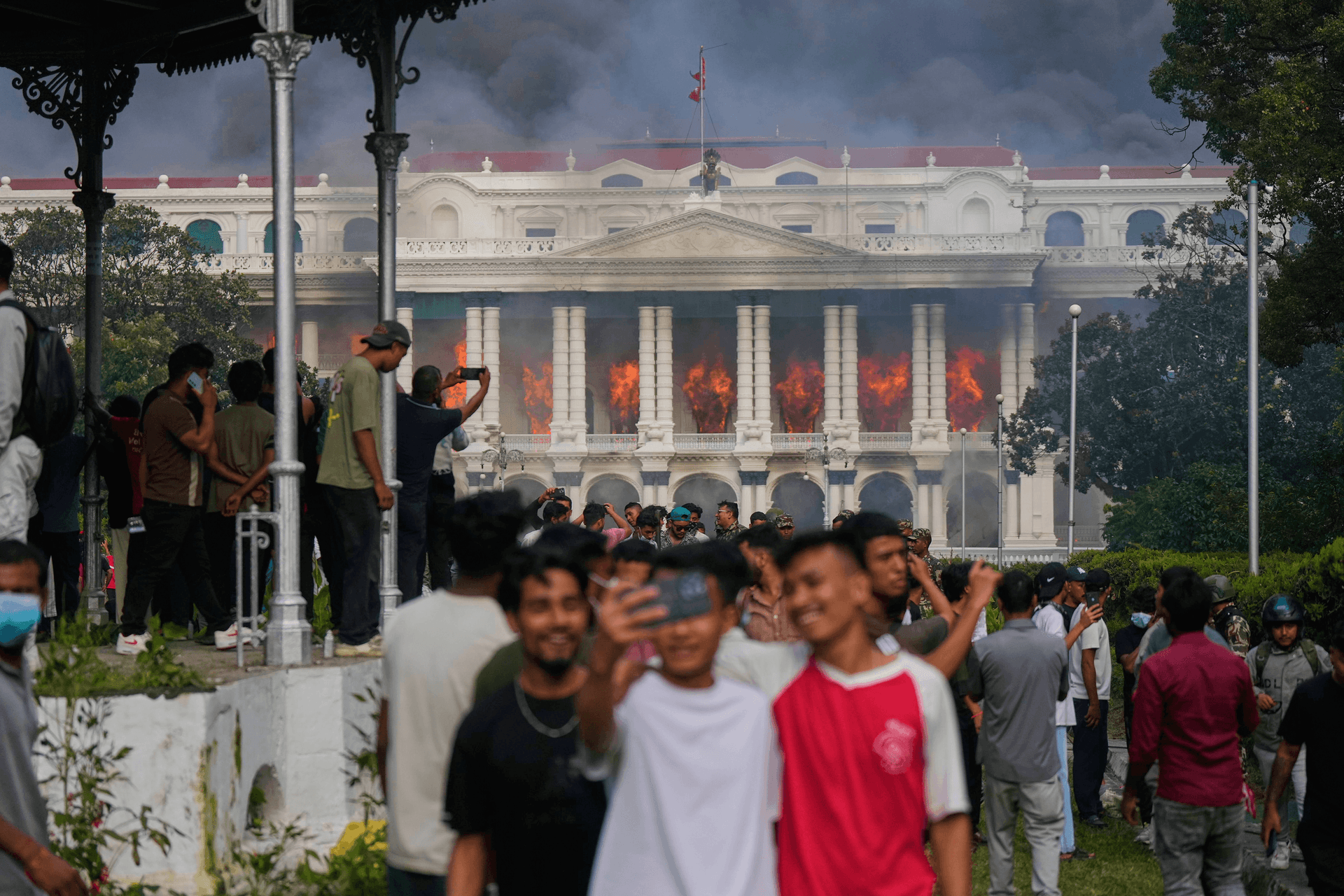 Jovens registram incêndio no palácio do governo durante protestos no Nepal. Legenda da imagem. Reprodução: Juan Silva/g1