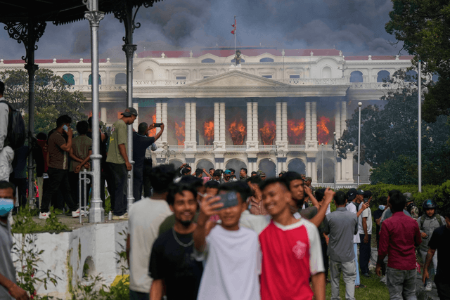Jovens registram incêndio no palácio do governo durante protestos no Nepal. Legenda da imagem. Reprodução: Juan Silva/g1